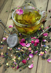 green tea. cup of green tea with flowers and fruit pieces. blend tea