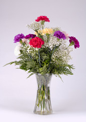 Flower arrangement of carnations in a vase isolated on white