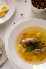 Delicious fragrant soup based on quail broth in a white dining plate. Slices of meat, quail egg, dill, bulgur, pepper and crackers - a useful and simple dish. Turkish cuisine.