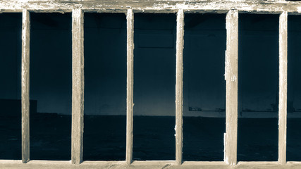 Window of an abandoned house made with wooden rods.