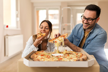 Happy couple eating pizza.