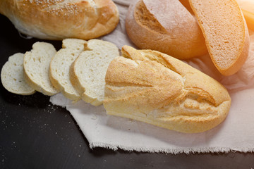 Bakery - fresh homemade sliced bread on black chalkboard background. Flat lay, top view, copy space for your text