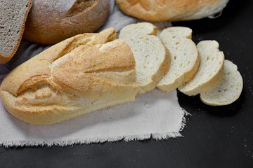 Bakery - fresh homemade sliced bread on black chalkboard background. Flat lay, top view, copy space for your text