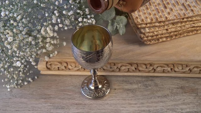 Jewish passover matzah on decorated silver wine cup with matzah, jewish symbols for pesach holiday.