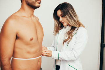 Female sports nutritionist attending patient in her clinic