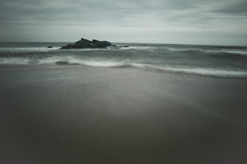 Long exposure of the New Jersey Shore. Waves are crashing on rocks creating a smoothing of the sea.