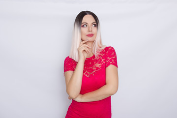 Young blonde woman over white background in bright pink dress