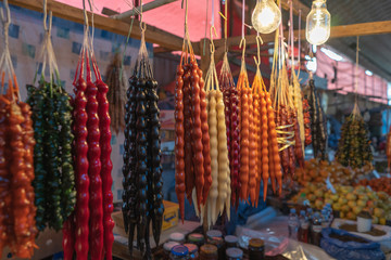 Churchkhela. Traditional Georgian homemade sweets with hazelnuts, walnuts, grape juice, honey (sugar), wheat flour (corn flour). Dessert sold in local food market in Tbilisi, Georgia.