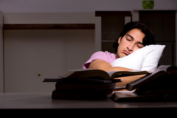 Male handsome student preparing for exams late at home 