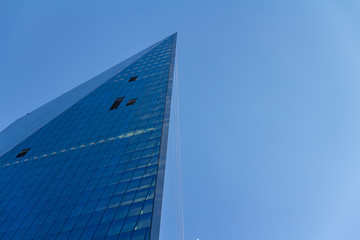 Abstract glass facades at a bright sunny day on the blue sky background. Economy finances and business activity concept. Low angle view © CupOfSpring
