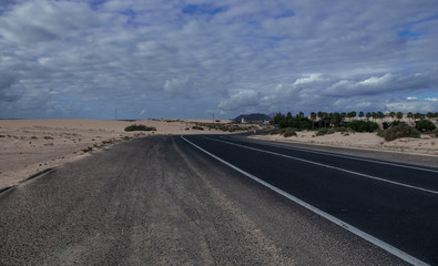 long strip of asphalt in the sand dunes of Fuerteventura, Canary Islands