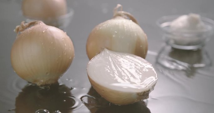 Onion halves being splashed by water in slow motion.