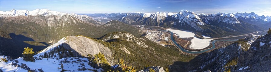 Wide Panoramic Landscape of Snowcapped Mountain Peaks and Bow River Valley from Summit of Anklebiter Ridge in Alberta Foothills of Canadian Rockies near Banff National Park