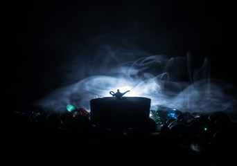 Antique Aladdin arabian nights genie style oil lamp with soft light white smoke, Dark background.