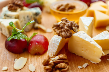 cheese plate, camembert slices with nuts and grapes. delicious snack, banquet, gourmet food