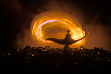 Antique Aladdin arabian nights genie style oil lamp with soft light white smoke, Dark background.