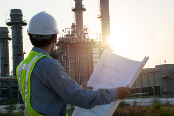 Engineers male are looking at blueprint for workers security control at power plant. Energy power...