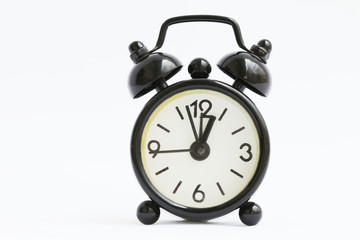 Old retro black alarm clock on isolated white background