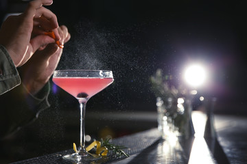 Barman making cosmopolitan martini cocktail at counter, closeup. Space for text
