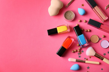 Flat lay composition with cosmetics, bottles of  nail polish and space for text on color background