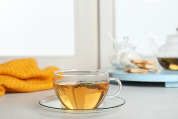 Cup of fresh tea on windowsill indoors. Winter drink