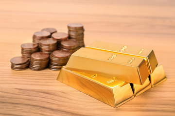 Stacked gold bars and coins on table. Space for text
