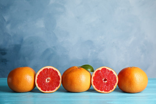 Fresh tasty grapefruits on table against color background. Space for text © New Africa