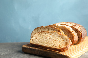 Board with bread on grey table, space for text