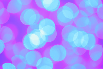 Blurred view of festive lights on color background. Bokeh effect