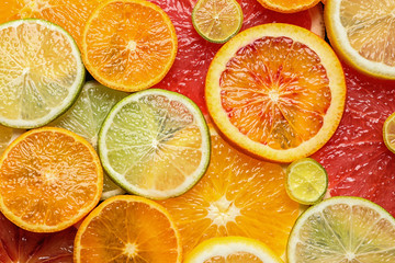 Slices of fresh citrus fruits as background, top view