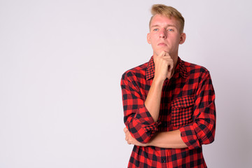 Portrait of young blonde hipster man thinking