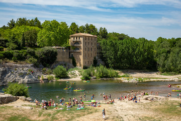 Swimming, kayaking and canoeing under the arches of the Pont du Gard in France on a hot summer day