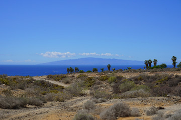 A view of the ocean, the desert and La Gomera island in Golf Costa Adeje, Tenerife, Spain.