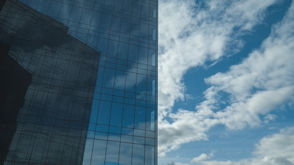 Fototapeta na wymiar Blue sky, reflected in a sleek wall of a high building