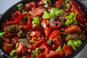 A pan with meat ragout with red and green pepper and tomatoes
