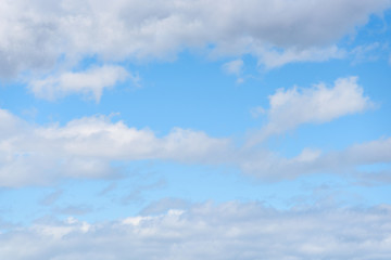 Obraz premium Peaceful nature background with stripes of white fluffy clouds and blue sky