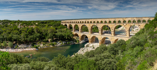 Naklejka premium Panoramic view of the magnificent three tiered Pont Du Gard aqueduct was constructed by Roman engineers in the 1st century AD in the south of France