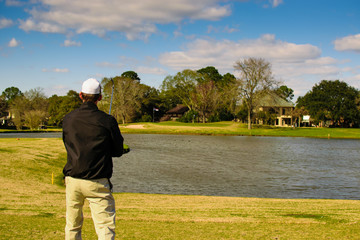 Golfer looking at the hole planning his shot with golf club in frame