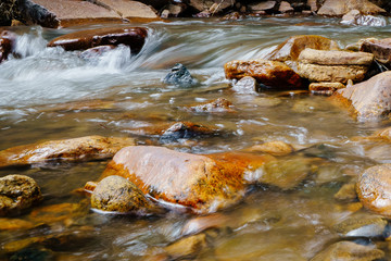 Colorado Rocky Mountains National Park. Bear Creek. Mountain river runs through the forest in the spring. Stones and rocks in the water