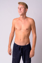 Fototapeta premium Portrait of happy young blonde man thinking and looking up shirtless