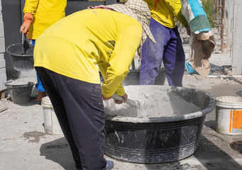 Construction worker mixing cement.