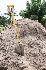 Shovel placed on a pile of sand for construction work. It is used for scooping sand