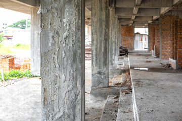 Concrete structure beam column for building under construction with brick layer wall.