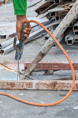 Welder worker welding steel structure outdoor at building construction site without protection.