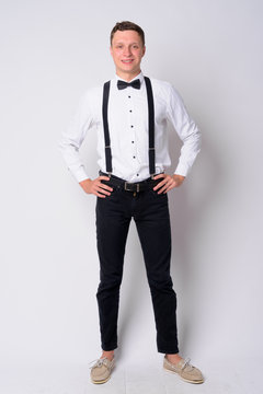 Full body shot of happy young businessman with suspenders smiling