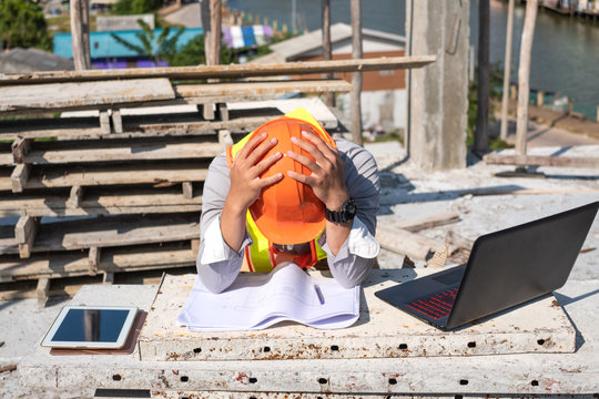 Stress engineer or architect with laptop and tablet holding hands at his head. He is having problems in work. Engineering concept.
