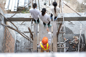 Angry engineer boss pointing finger threatens colleague at construction site. top view.