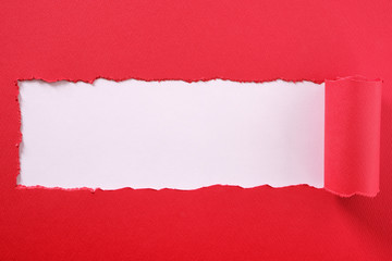 Torn red paper strip curled edge center frame white background
