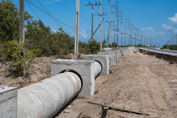 Concrete drainage tank or pipe being installed on construction site.