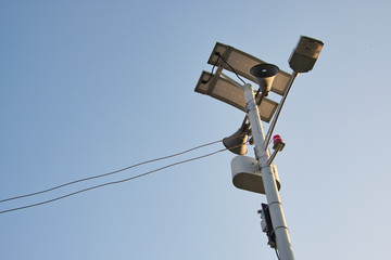 Obraz premium Solar street light and speaker on thin tower pole.